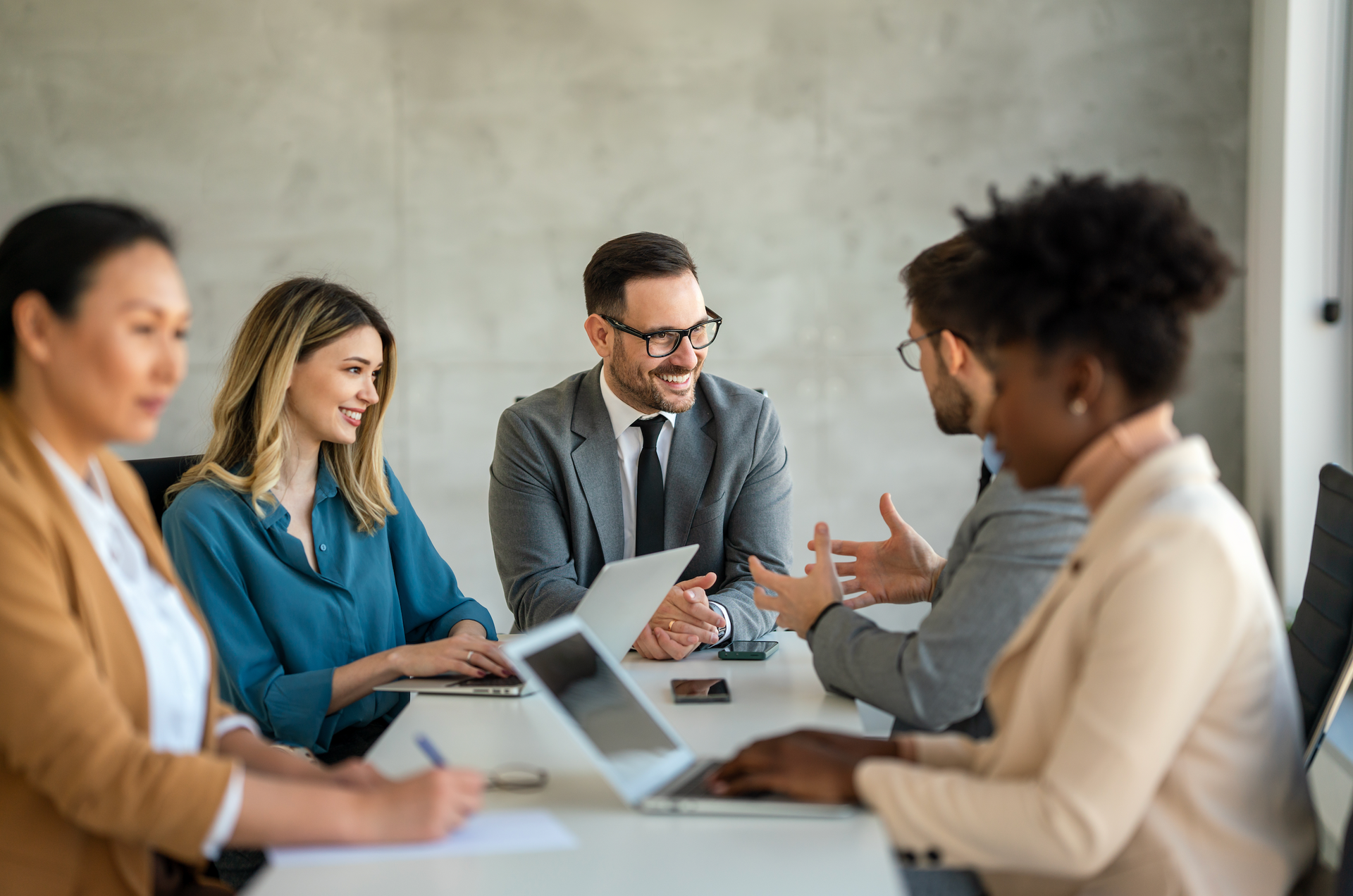 A group of business people are sitting around a table having a meeting.