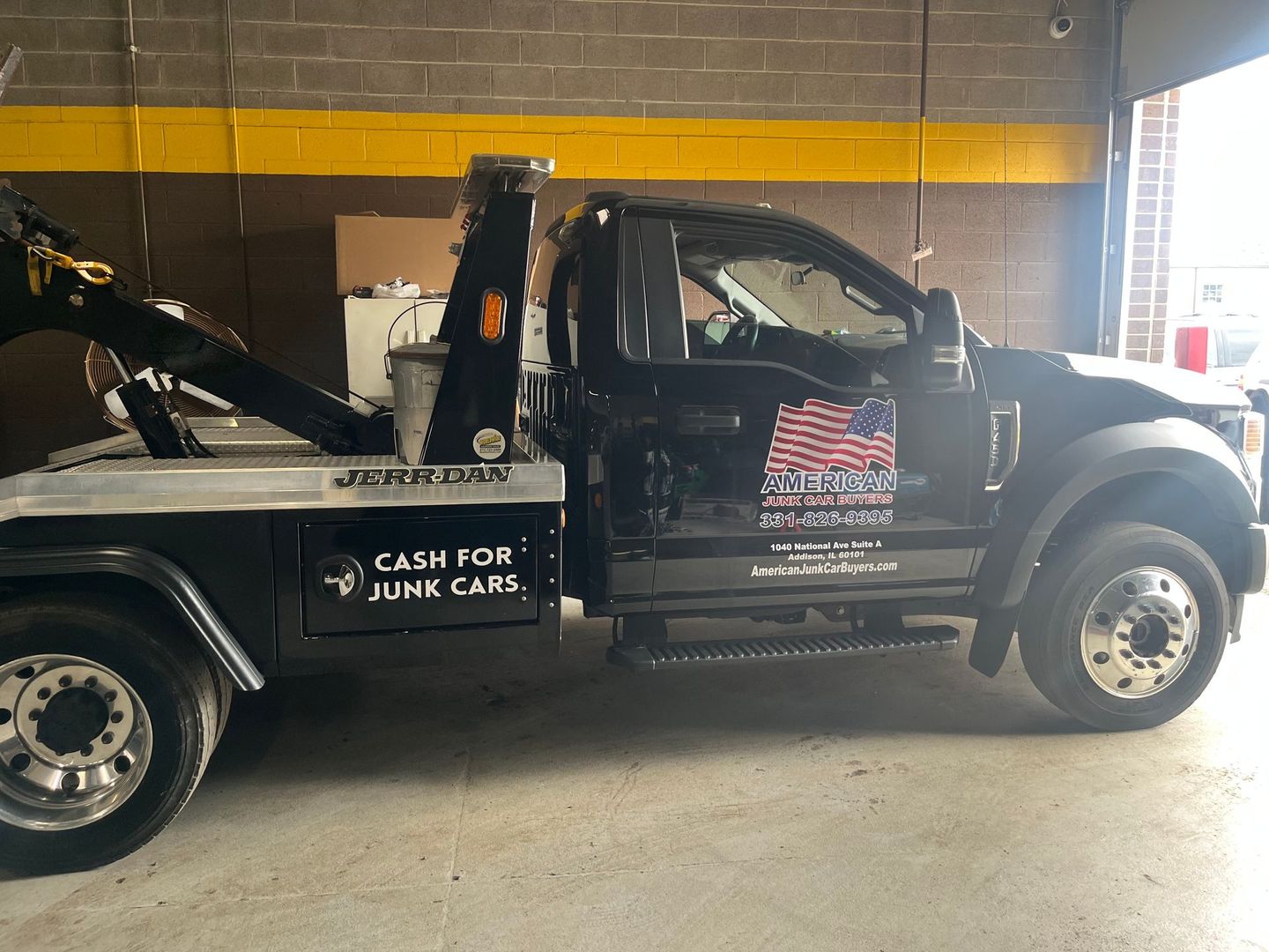 Image of a tow truck with American Junk Car Buyers logo