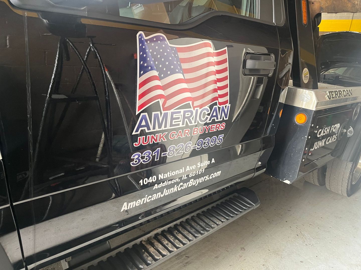 Image of a tow truck with American Junk Car Buyers logo