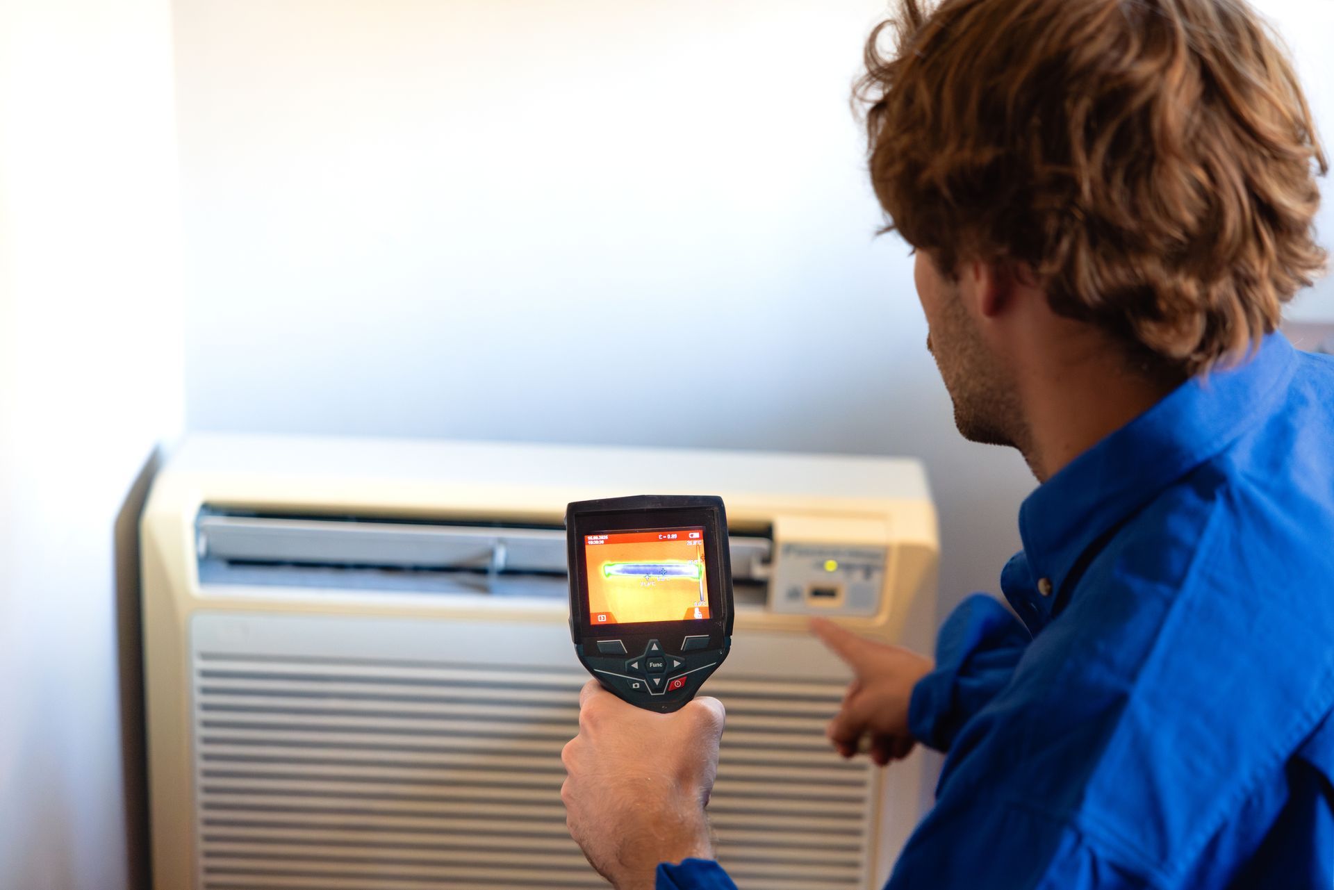 Technician checking air conditioner with thermal camera. Technician checking air conditioner with thermal camera.