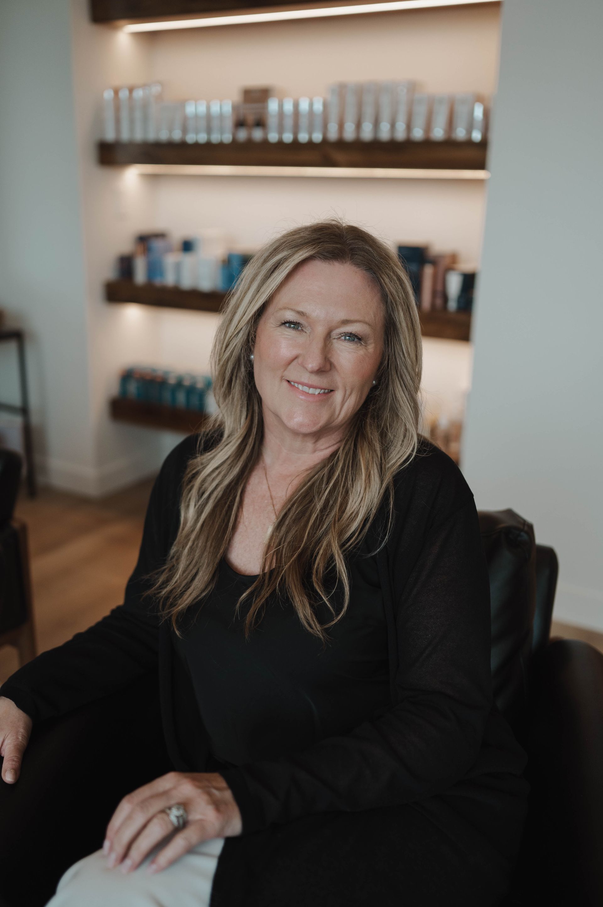A woman in a black shirt is sitting in a chair