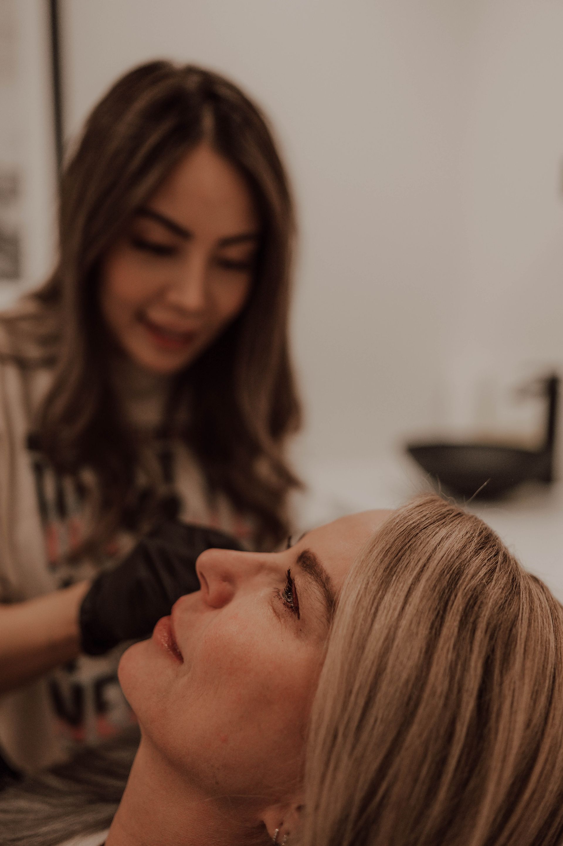 a woman is touching her face with her hand and looking over her shoulder .
