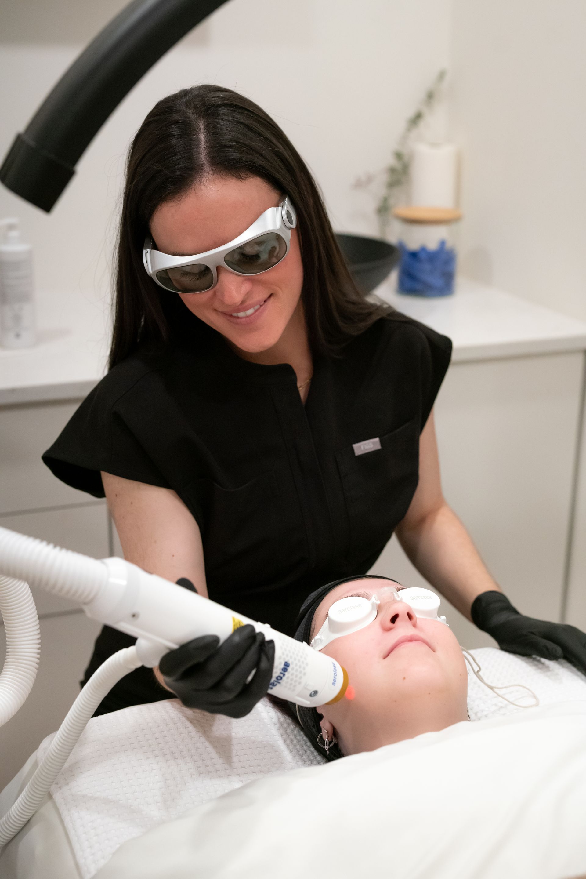 Dentist treating a patient with a dental instrument, both wearing protective eyewear