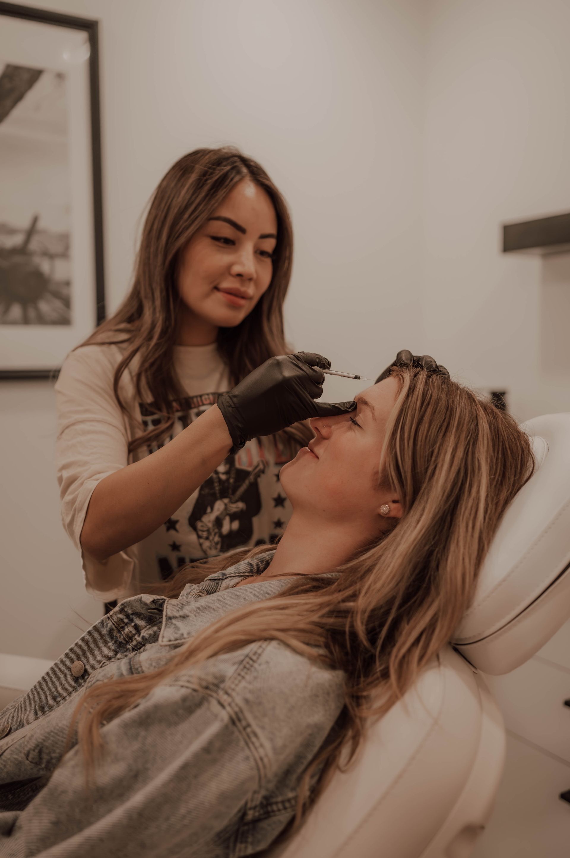 Cosmetic treatment in a spa, technician applying a procedure to a reclining client