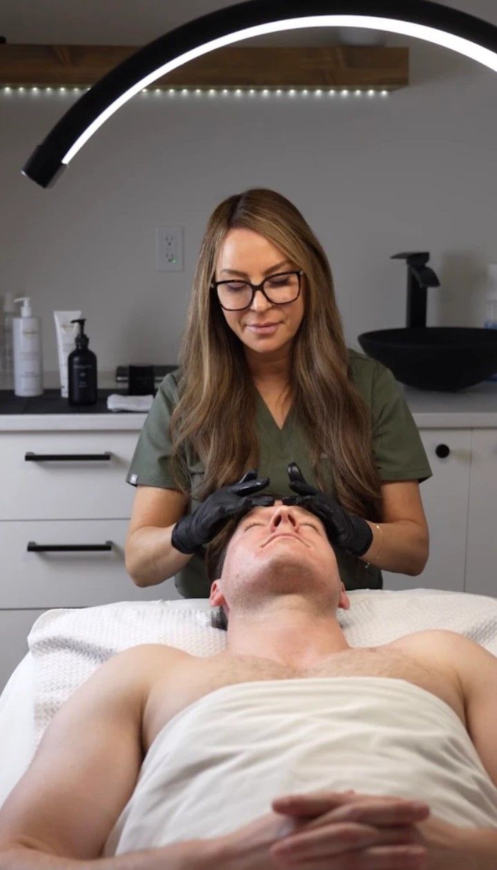 A person receiving facial treatment by a medical professional in a well-lit clinic.