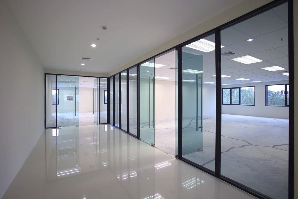 An Empty Office Building with a Lot of Windows and Sliding Glass Doors — Bulli Glass in Helensburgh, NSW