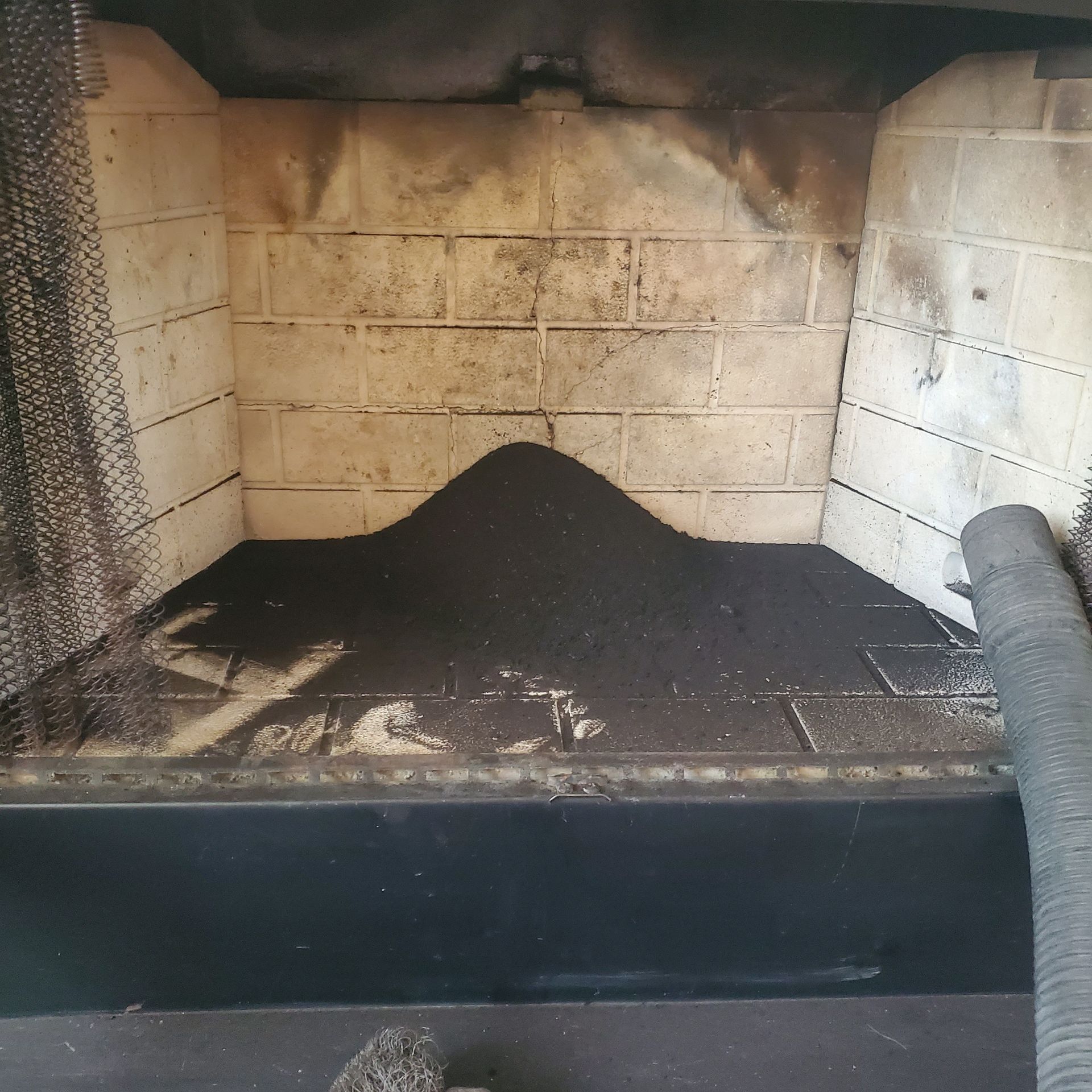 Charcoal pile in a soot-stained fireplace or wood stove interior