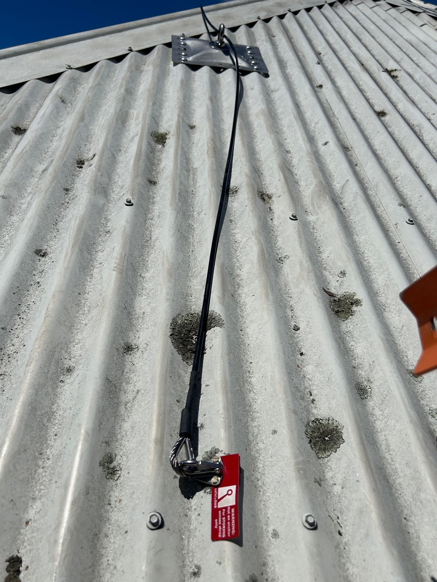 A roof with a rope attached to it and a sign on it.