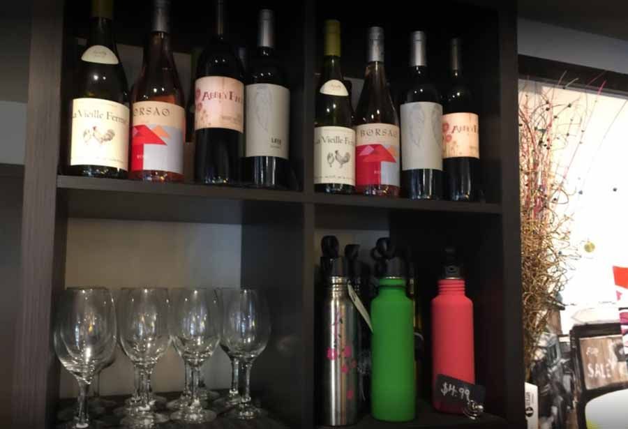 A shelf with bottles of wine and glasses on it