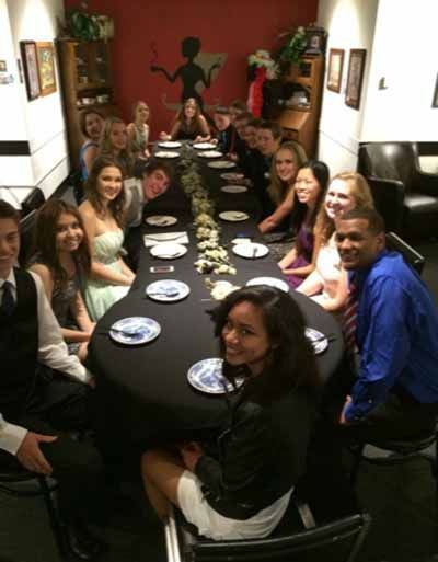 A group of people are sitting around a table with plates on it