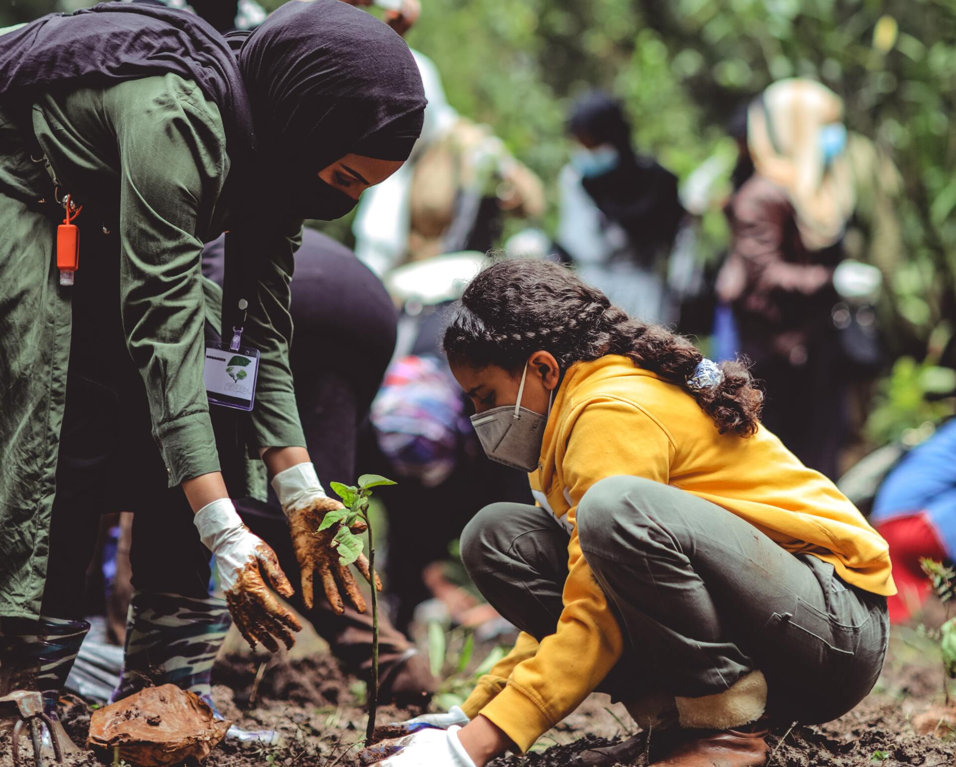 A Woman Helps a Child Plant a Tree For ESG Reporting