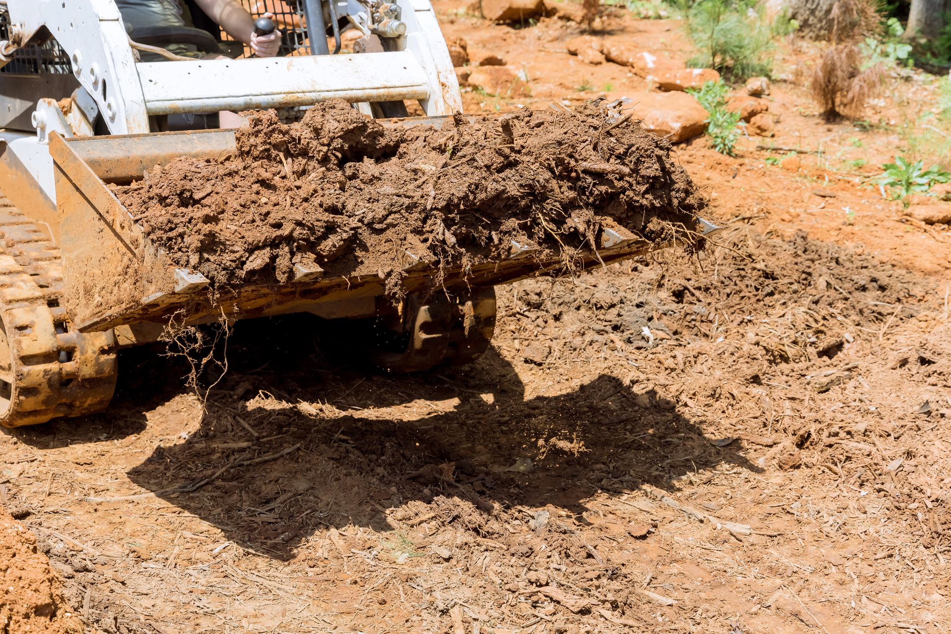Bulldozer blade pushing muddy dirt on a construction site