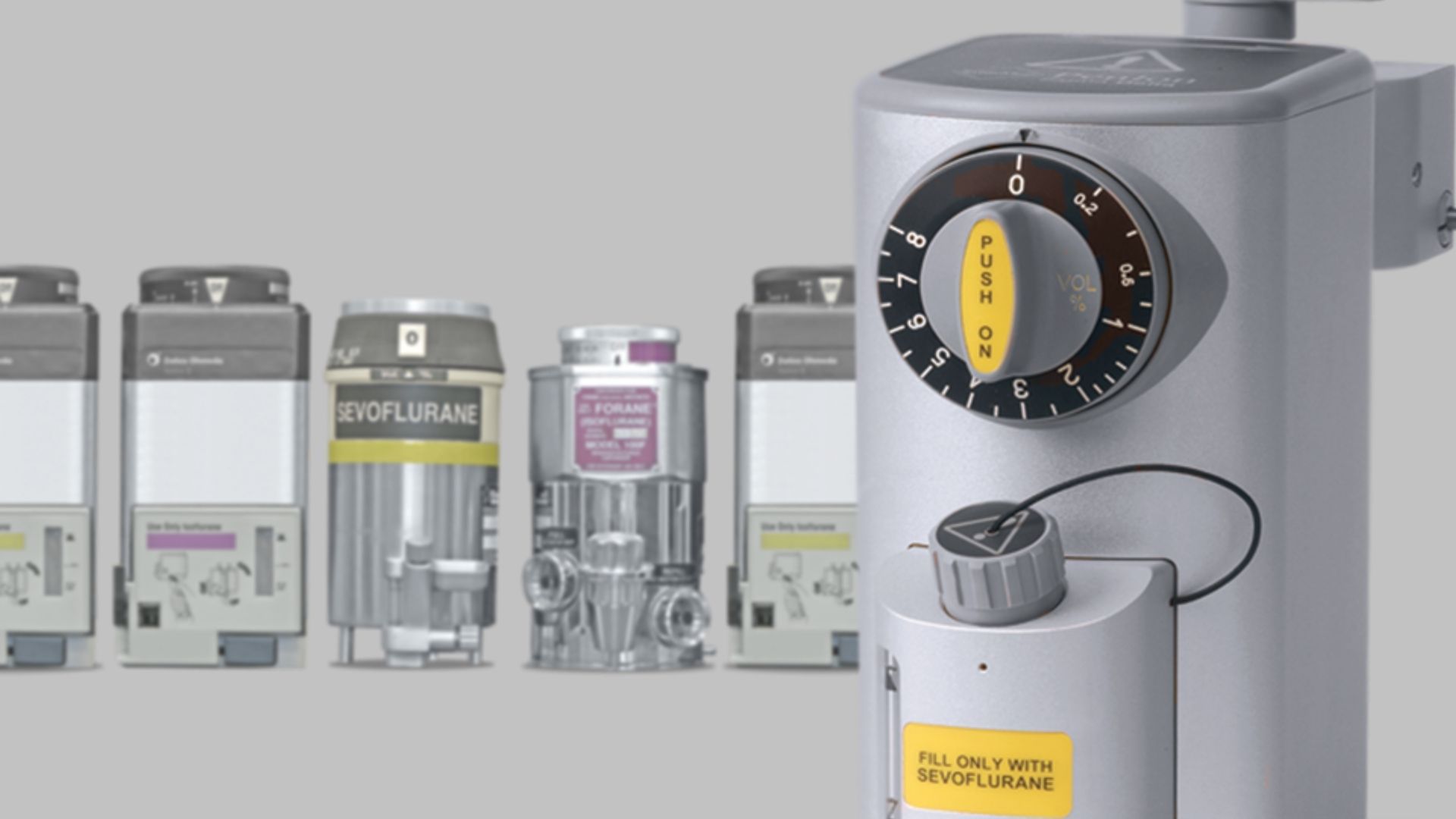 Industrial machinery lineup with a large gray control dial in the foreground, set against smaller units in back
