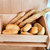 Assortimento di pagnotte e panini in una cassa di legno su uno scaffale