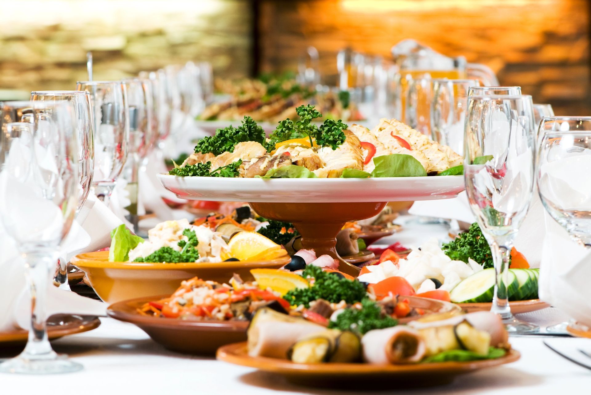 Elegante tavolo da banchetto con piatti assortiti, calici da vino e un'atmosfera luminosa a lume di candela.