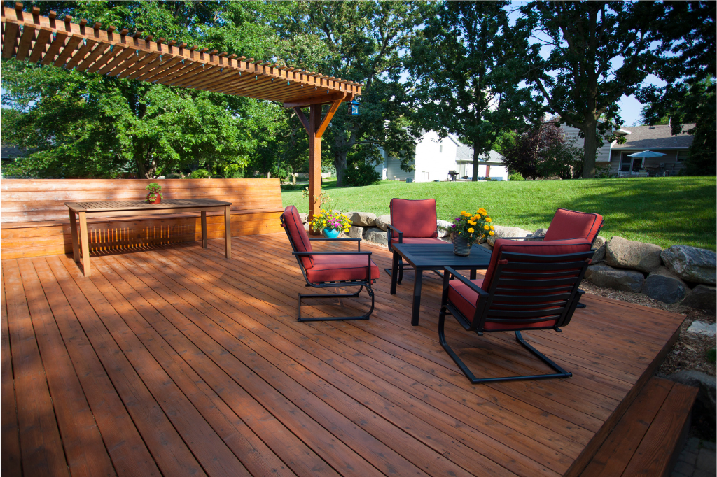 A wooden deck with a pergola and patio furniture