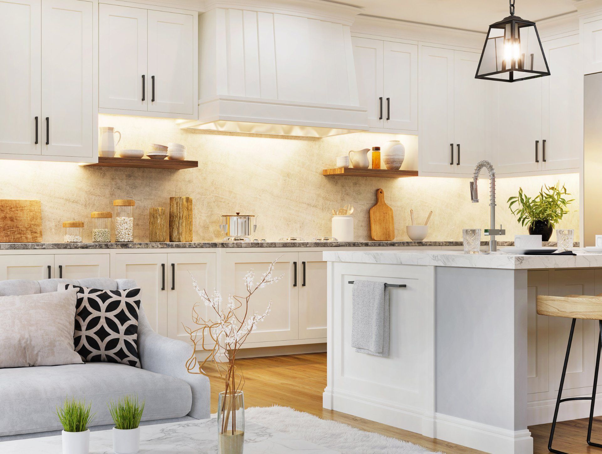 A modern white kitchen featuring shaker cabinets, a marble backsplash, wooden shelves, a kitchen island, and a sofa.