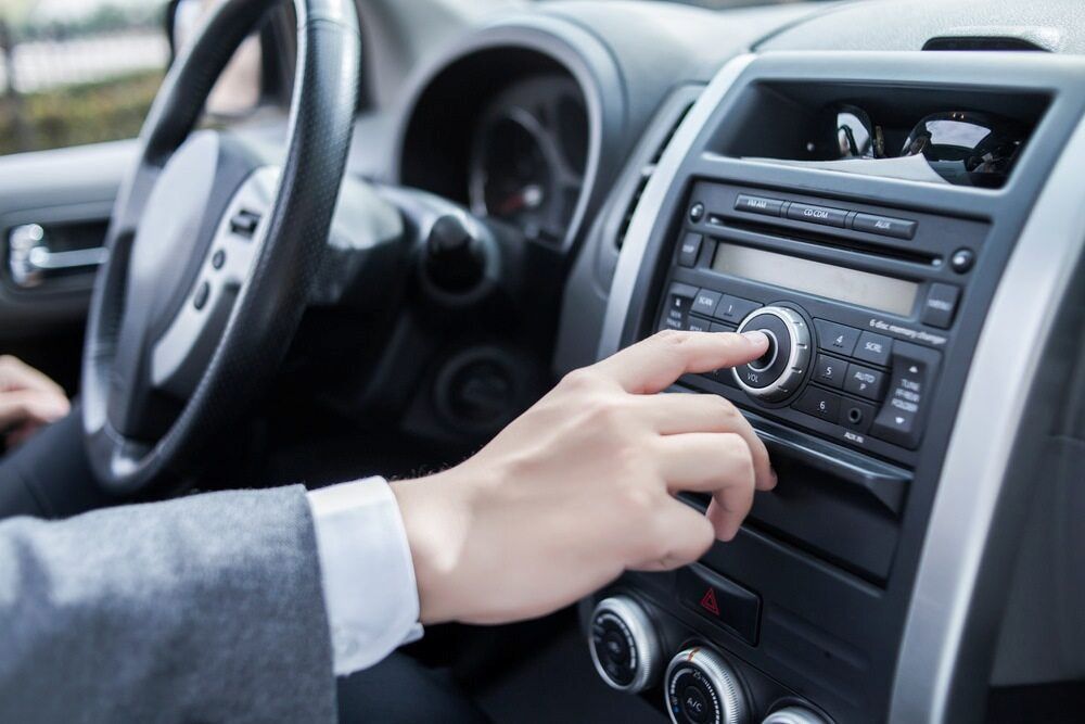 A Person Is Adjusting The Radio In A Car — SJM Autocare in Mullumbimby, NSW