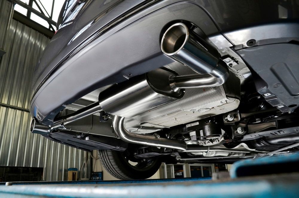 The Exhaust Pipe Of A Car Is Sitting On A Lift In A Garage — SJM Autocare in Mullumbimby, NSW