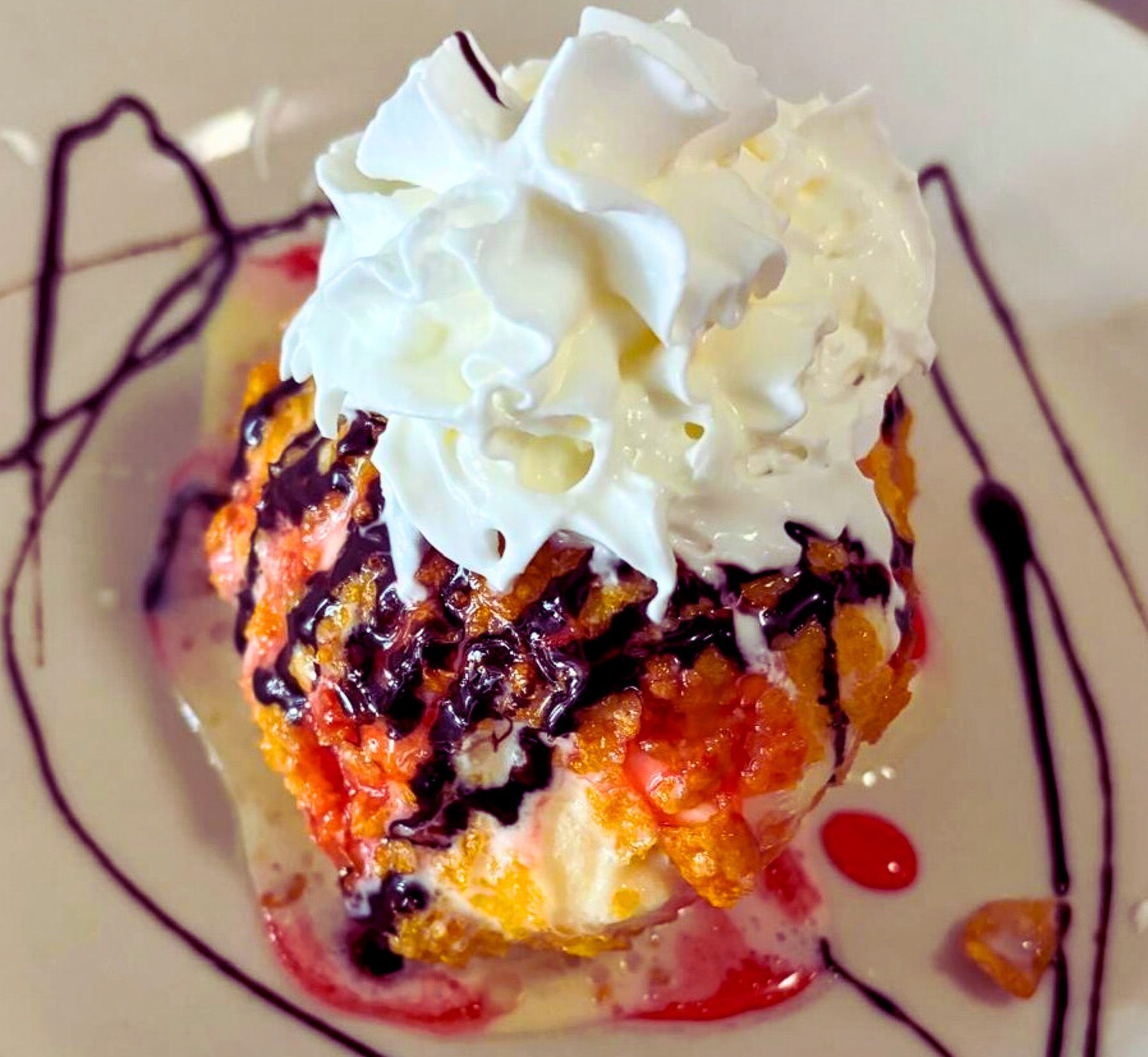 Fried ice cream topped with whipped cream and chocolate sauce