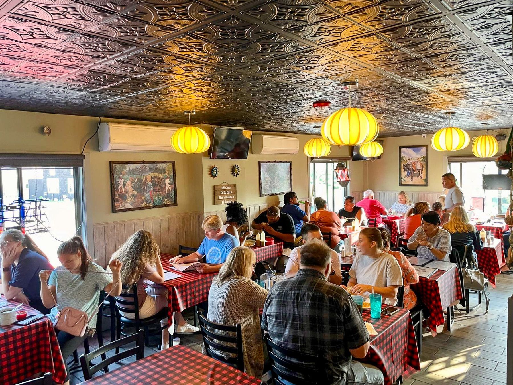 Guests eating and hanging out inside El Sureño near the bar