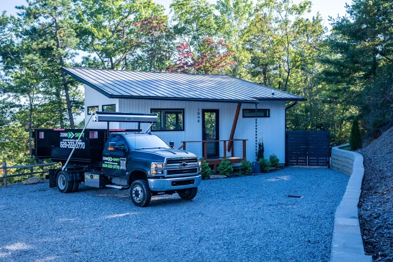 Junk Shift truck with a roll-off dumpster at a commercial property in Western North Carolina