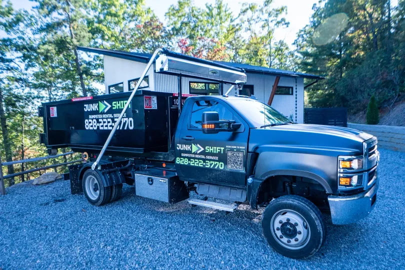 Dumpster rental truck parked in front of residential home