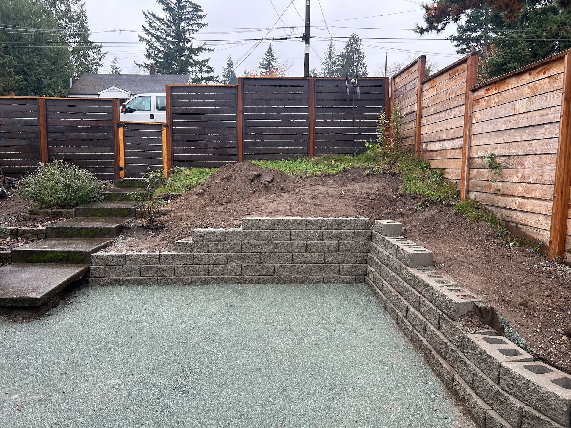 Backyard with a drained rectangular pool, stone steps, and wooden privacy fencing