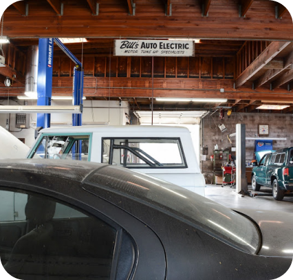 A car is parked in front of a bills auto electric sign | Bill's Auto Electric Repair Inc