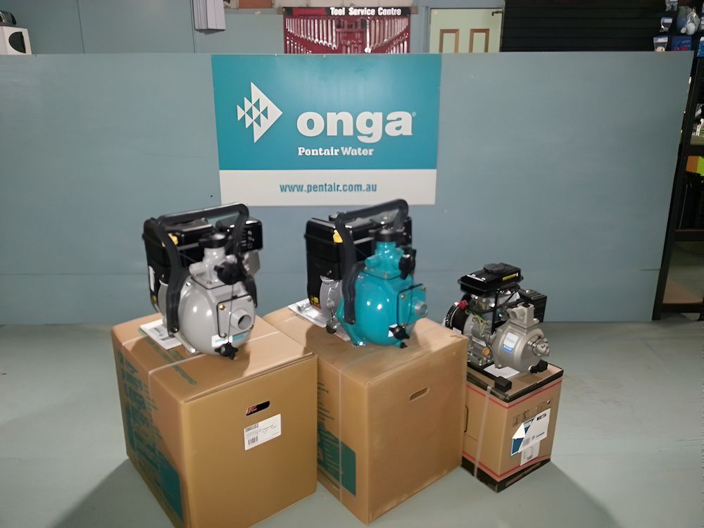 Three Water Pumps Are Sitting On Cardboard Boxes — Manning Valley Pumps And Irrigation In Wingham, NSW