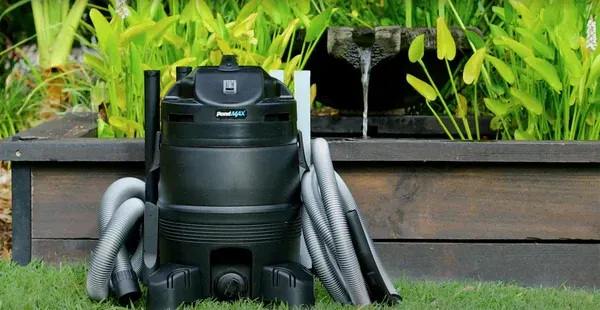 A vacuum cleaner is sitting on top of a lush green lawn next to a wooden box. — Manning Valley Pumps And Irrigation In Wingham, NSW