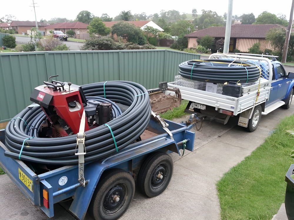 A Truck Is Pulling A Trailer With A Bunch Of Pipes On It — Manning Valley Pumps And Irrigation In Forster, NSW