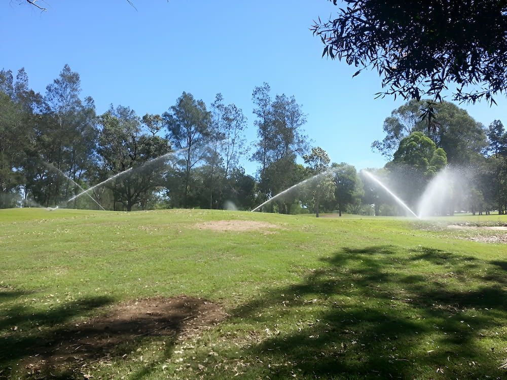 Several Sprinklers Spray Water On A Lush Green Field — Manning Valley Pumps And Irrigation In Wingham, NSW