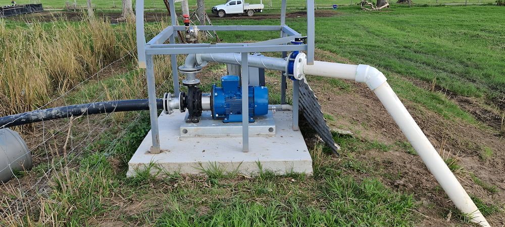 A Water Pump Is Sitting In The Middle Of A Grassy Field — Manning Valley Pumps And Irrigation In Wingham, NSW
