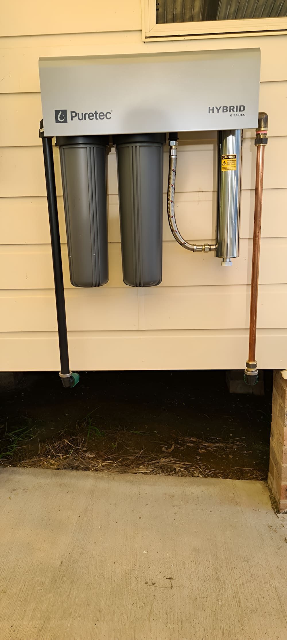 A Water Filter Is Hanging On The Side Of A House — Manning Valley Pumps And Irrigation In Forster, NSW