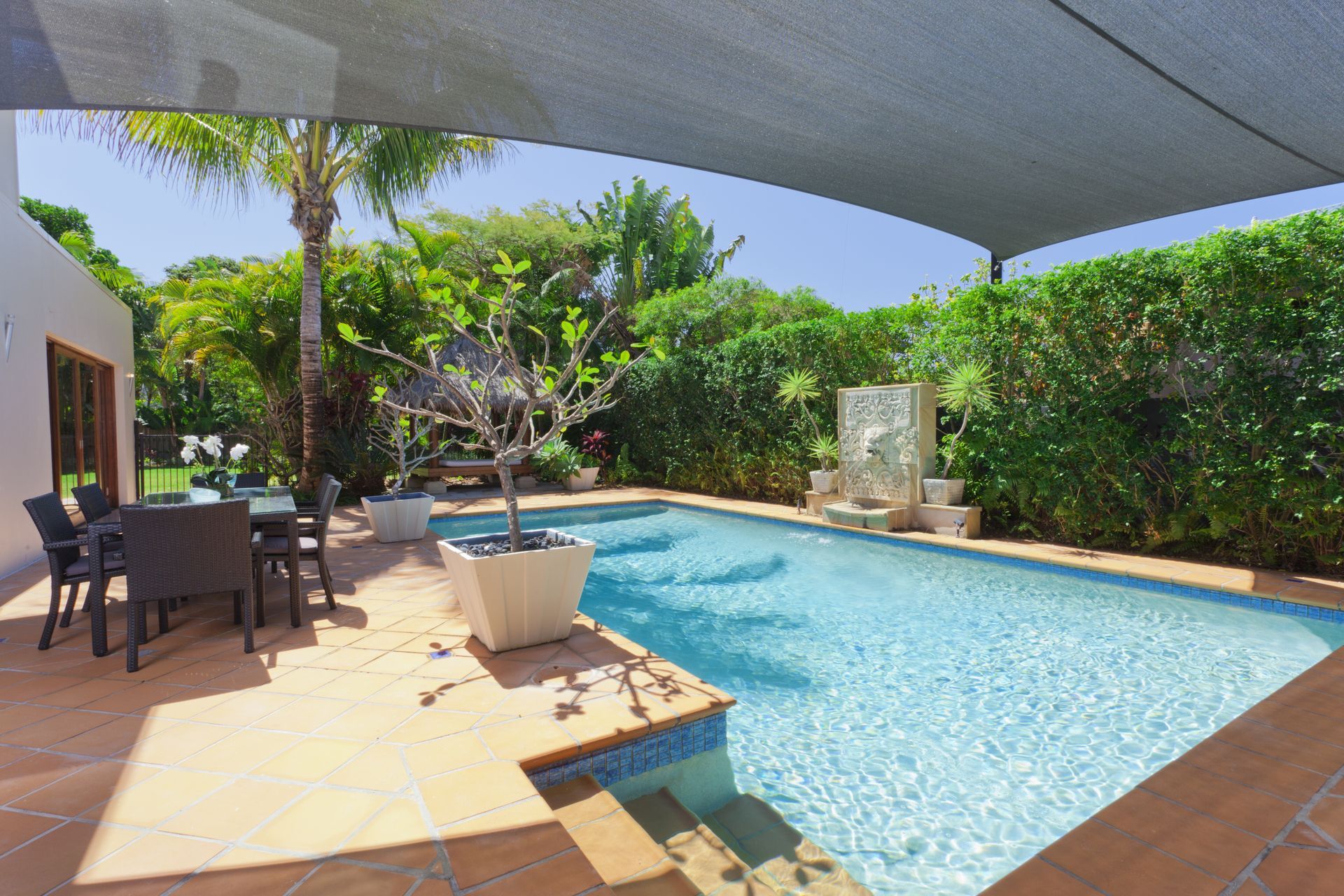 A large swimming pool is surrounded by a patio with a table and chairs. — Manning Valley Pumps And Irrigation In Wingham, NSW