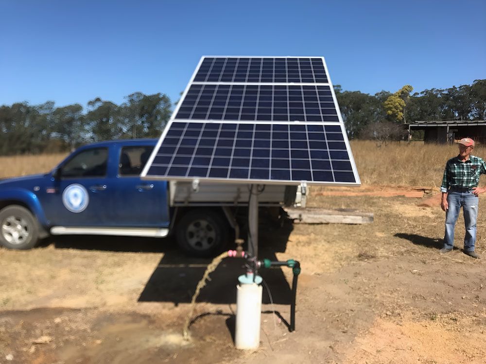 A Man Next To A Truck With A Solar Panel Attached To It — Manning Valley Pumps And Irrigation In Wingham, NSW
