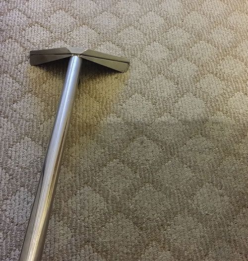 A vacuum cleaner is sitting on top of a carpet.