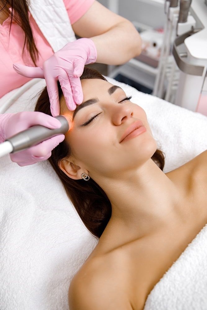 A Woman is Getting a Facial Treatment at a Beauty Salon — Aria Skin & Beauty in Gympie, QLD