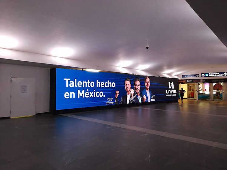 Gran letrero digital en una estación de metro con el texto