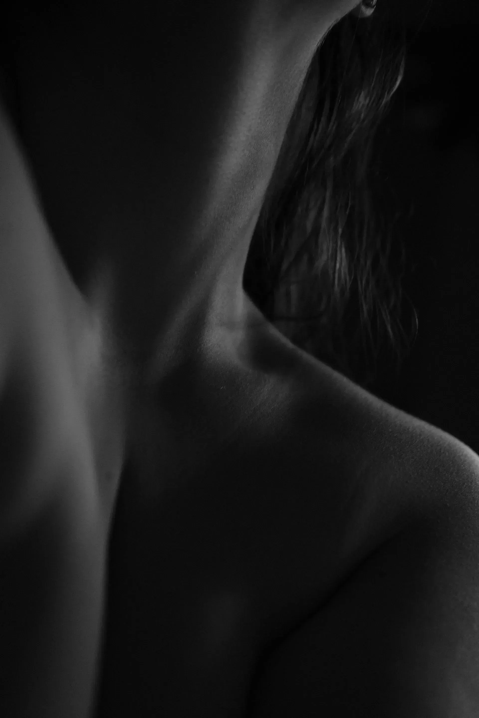 Monochrome close-up of a shoulder and neck in dramatic low light