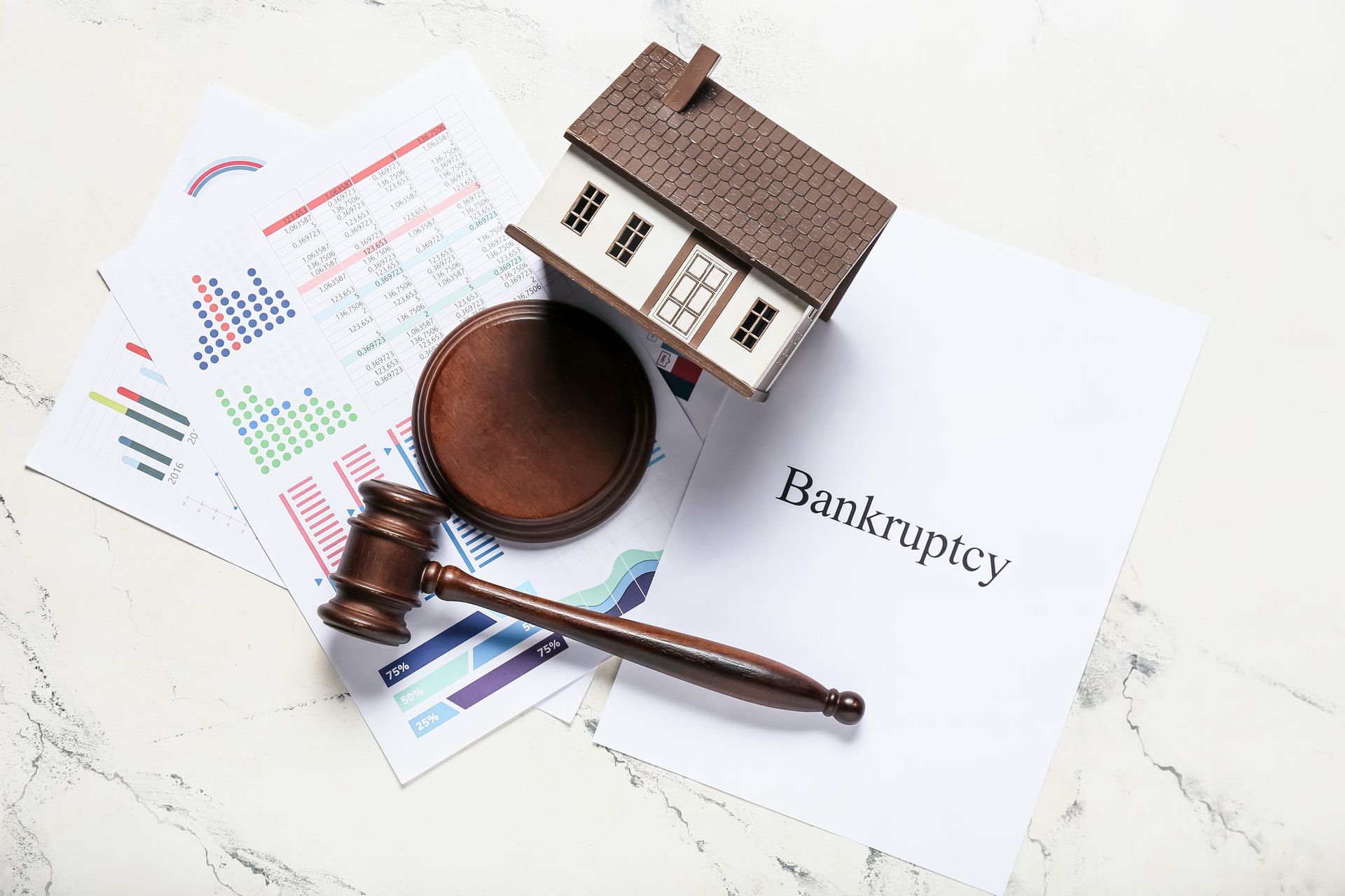 Gavel, house model, and bankruptcy document on a desk, suggesting a foreclosure or legal dispute