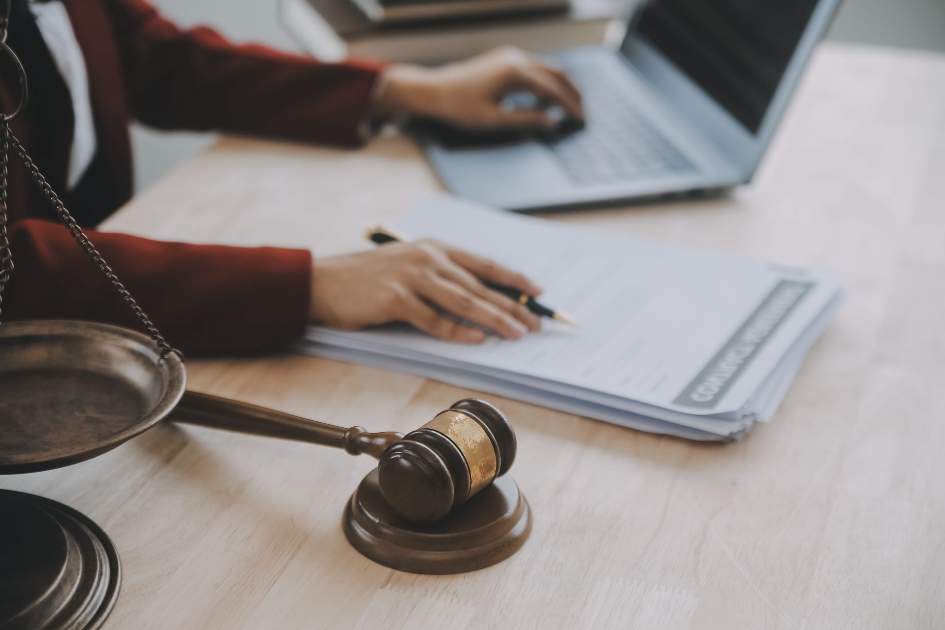 Lawyer reviewing documents with a gavel and magnifying glass on a desk