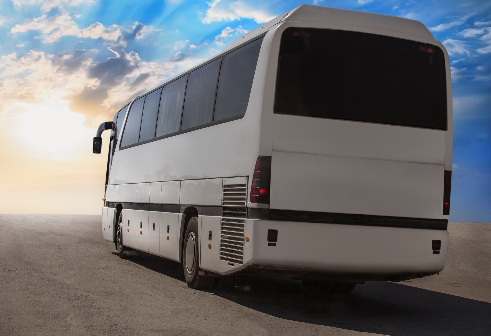 A white bus is parked on the side of the road.