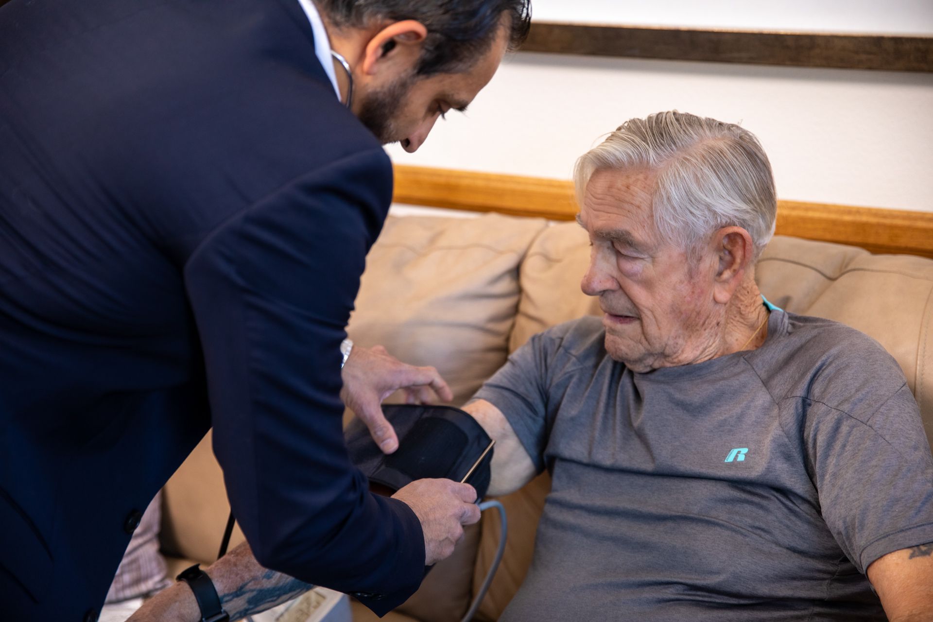 An old man receiving an in-home examination by a Doctor