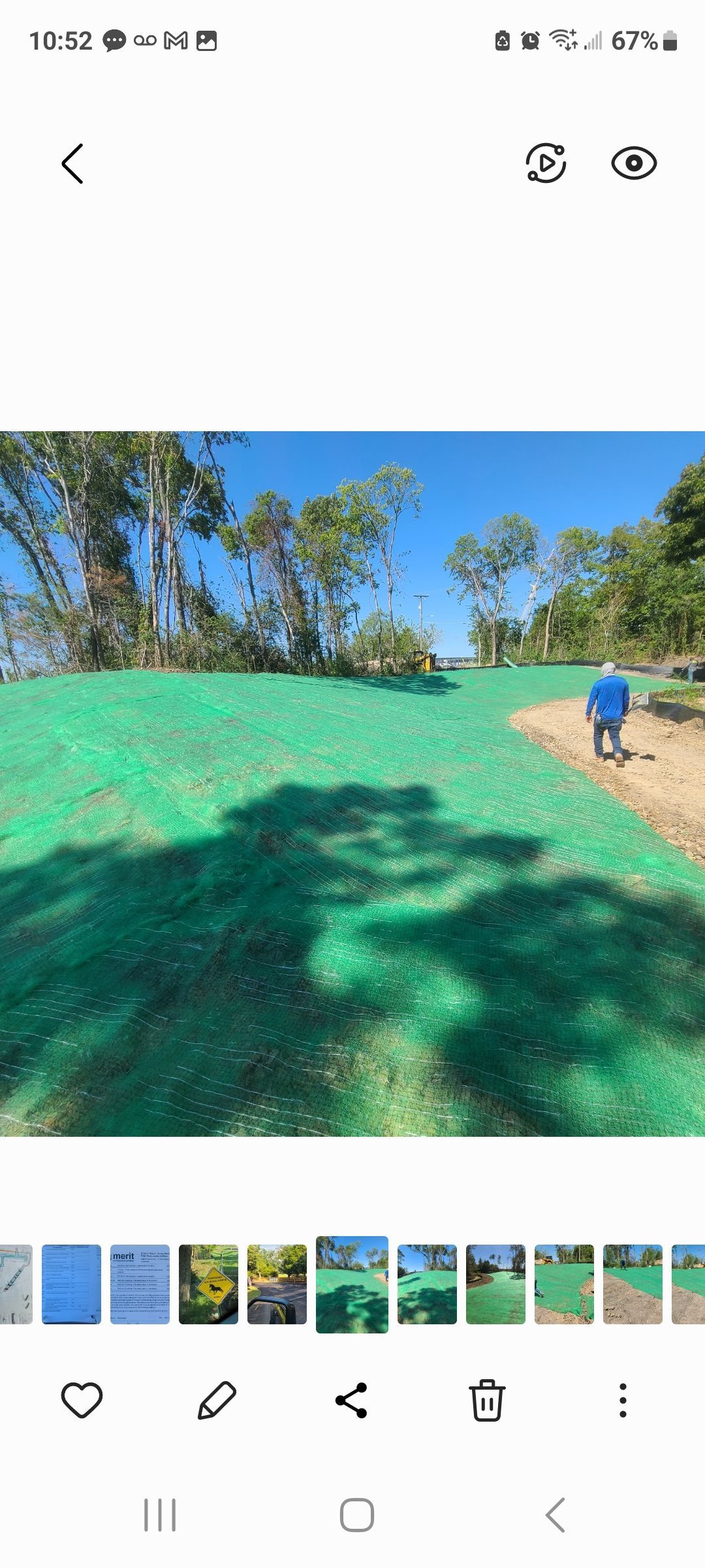 Golf course fairway with green turf, trees, blue sky, and a golfer walking on the right
