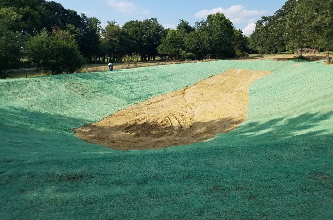 Green painted landscape with a central sand-filled depression outdoors