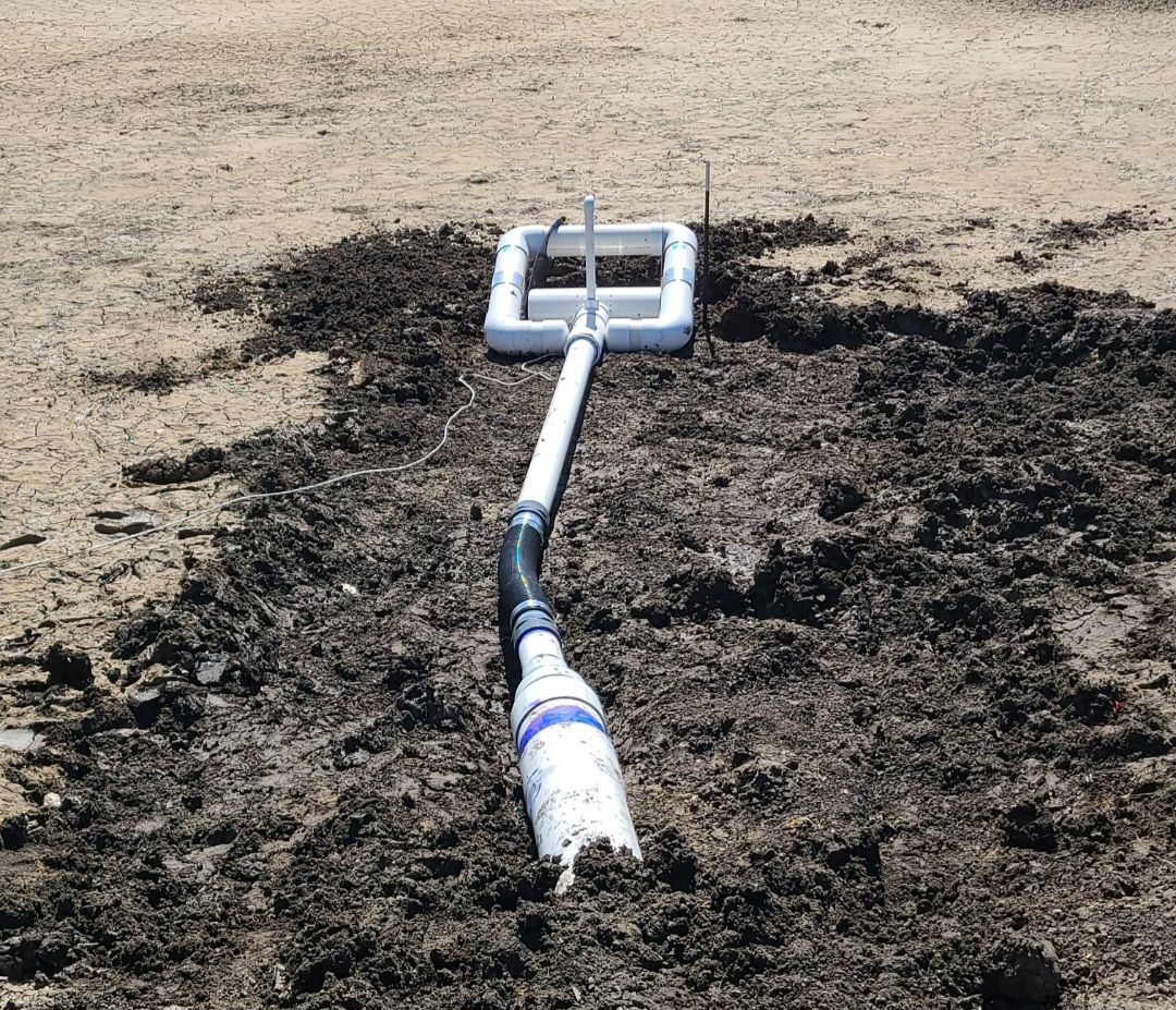 White golf club lying on scorched grass near a blackened patch of ground