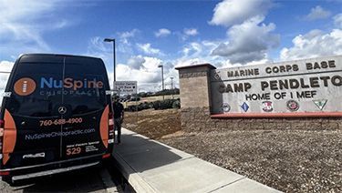 Black NuSpire van parked by Camp Pendleton Marine Corps Base sign at the entrance.