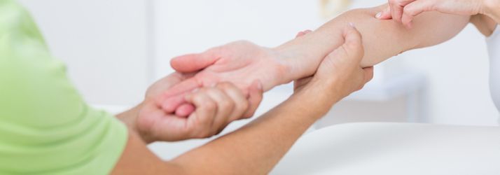 Hands clasped in a supportive gesture, with a child’s hand held by two adults against a bright white background